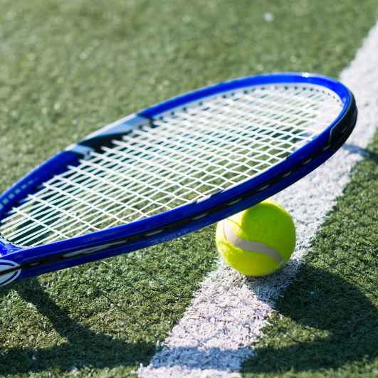 Basingstoke Tennis Courts A racket and tennis ball laid down on a high-quality Basingstoke tennis court.