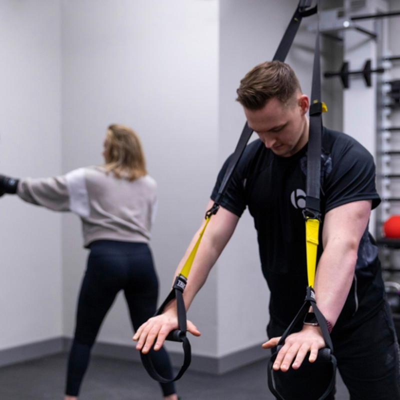 A male personal trainer in Basingstoke demonstrating how to use exercise bands.