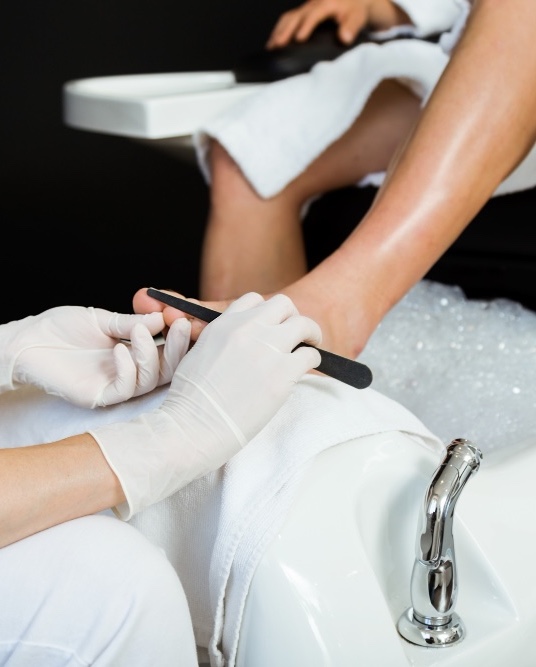 Pedicures Basingstoke A woman sat in a spa gown relaxing and enjoying a pedicure in Basingstoke.