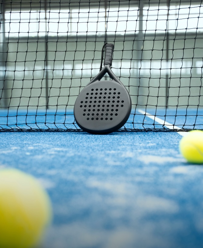 Padel Equipment Padel leaning on net.
